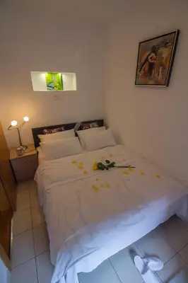 a bedroom with a white bed with flowers on it at Stan na Dan Banja Luka in Banja Luka