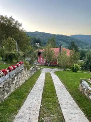 a stone path in front of a red house at Holiday Home Ajaz Bihac in Bihać