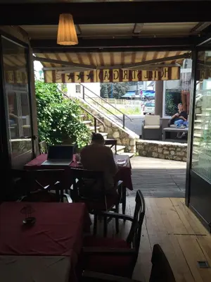 a man sitting at a table in a restaurant with a laptop at Hotel Stari grad in Jajce