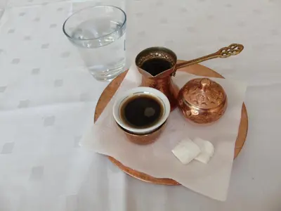 a table with a cup of coffee and a tea pot at Motel Kamenica in Bihać