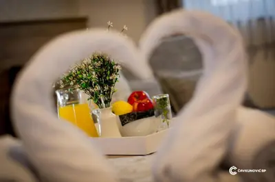 a plate of food with fruit and juice on a table at Motel Kamenica in Bihać