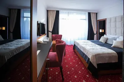 a hotel room with two beds and a desk at Hotel Exclusive President in Morančani