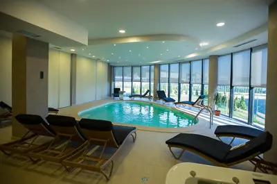a large swimming pool with chairs in a building at Hotel Exclusive President in Morančani