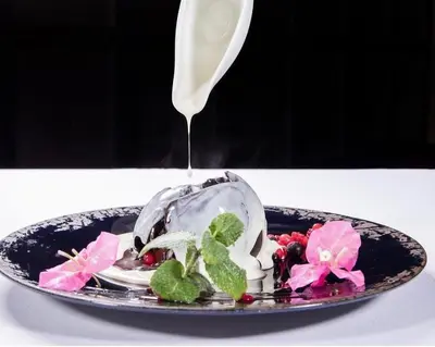 a plate of food with a sauce being poured on it at Hotel Exclusive President in Morančani