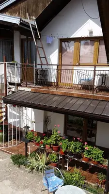 a house with a balcony with flowers and plants at Apartments Aida in Bihać