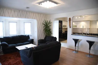 a living room with two couches and a kitchen at Apartment Mario in Livno