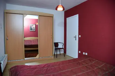 a bedroom with a bed and a red wall at Apartment Mario in Livno