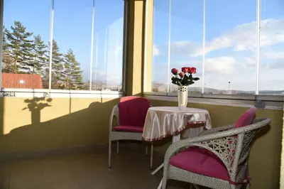 a table and chairs with a vase of flowers on it at Apartment Mario in Livno