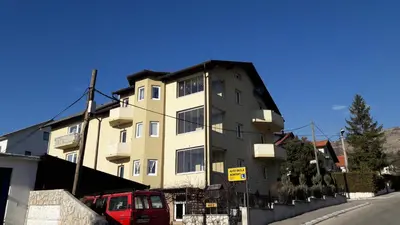 a building with a red van parked in front of it at Apartment Mario in Livno