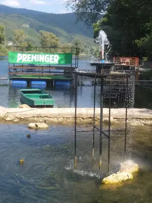a pier in the water with a sign in the water at Ribarska Vila in Donje Lohovo