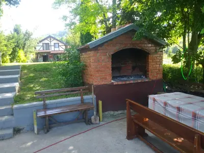 a brick oven with a bench next to it at Ribarska Vila in Donje Lohovo