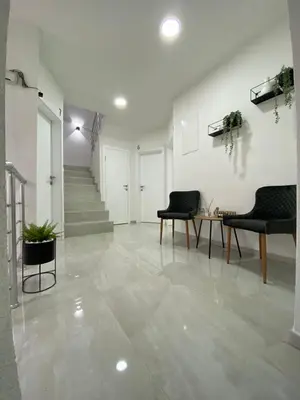 a hallway with two chairs and a table and stairs at Prenoćište Stari Grad - Old Town in Tuzla