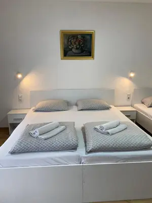 a white bed with two pillows on top of it at Prenoćište Stari Grad - Old Town in Tuzla