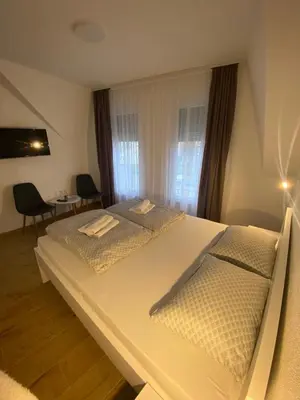 a bedroom with two beds and a table and chairs at Prenoćište Stari Grad - Old Town in Tuzla