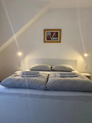 a bedroom with a bed with two pillows on it at Prenoćište Stari Grad - Old Town in Tuzla