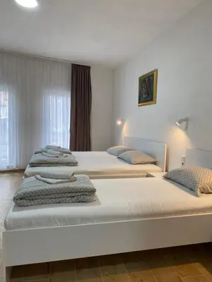a bedroom with three beds with towels on them at Prenoćište Stari Grad - Old Town in Tuzla