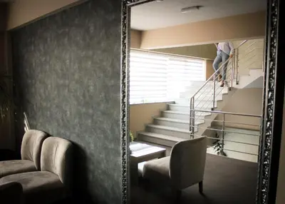 a man is walking up the stairs in a mirror at Hotel Brcko Gas Prijedor in Prijedor