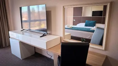 a room with a desk with a mirror and a bed at Hotel Brcko Gas Prijedor in Prijedor