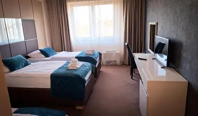 a hotel room with two beds and a television at Hotel Brcko Gas Prijedor in Prijedor