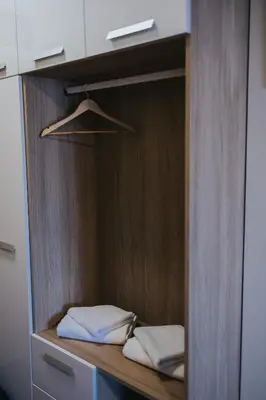 a closet with white towels on a wooden shelf at Hotel Brcko Gas Prijedor in Prijedor
