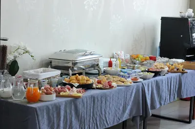 a table with many plates of food on it at Hotel Brcko Gas Prijedor in Prijedor