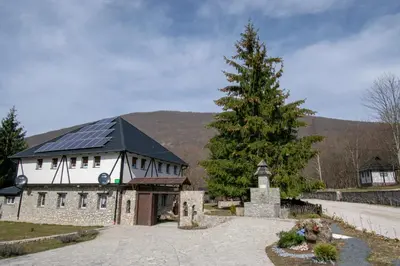 a large white building with a tree in front of it at Holiday park Hajducka cesma in Dubovsko