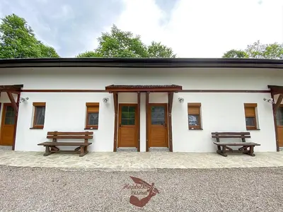 a building with two benches in front of it at Holiday park Hajducka cesma in Dubovsko