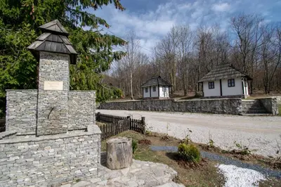 a stone wall with a house in the background at Holiday park Hajducka cesma in Dubovsko