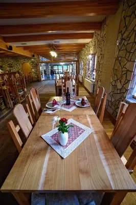 a dining room with a wooden table and chairs at Zlatna Nit Pansion in Bosanska Krupa