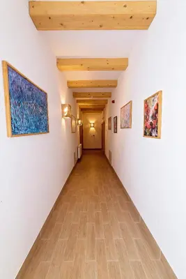 a hallway with white walls and a wooden ceiling at Zlatna Nit Pansion in Bosanska Krupa