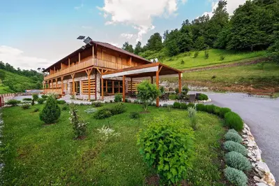 a log cabin on a hill next to a road at Zlatna Nit Pansion in Bosanska Krupa