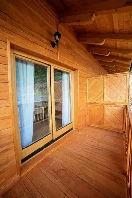 an empty room with a large window in a log cabin at Zlatna Nit Pansion in Bosanska Krupa