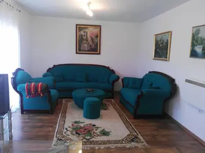a living room with two blue couches and a table at Apartment Beha in Bihać