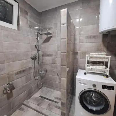 a bathroom with a washing machine and a shower at Apartment Beha in Bihać