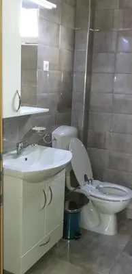 a bathroom with a white toilet and a sink at Apartment Beha in Bihać
