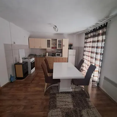 a kitchen with a white table and chairs in a room at Apartment Beha in Bihać