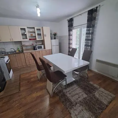 a kitchen and dining room with a white table and chairs at Apartment Beha in Bihać