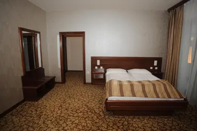 a hotel room with a bed and a mirror at Hotel Balkana Vidović in Mrkonjić Grad