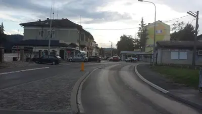 an empty street with cars parked on the road at Apartmani Kastel in Banja Luka