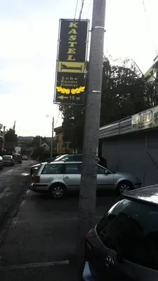 a sign on a pole in a parking lot with cars at Apartmani Kastel in Banja Luka
