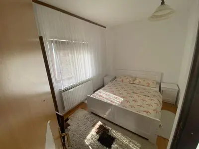 a small bedroom with a bed and a window at Lav Apartments in Bihać