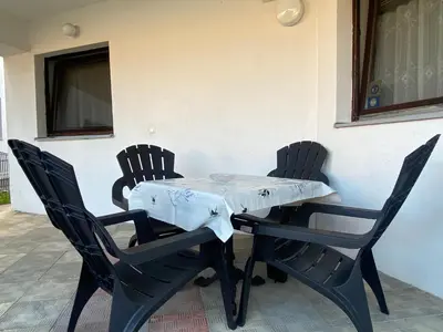 a table and chairs with a white table cloth on it at Lav Apartments in Bihać