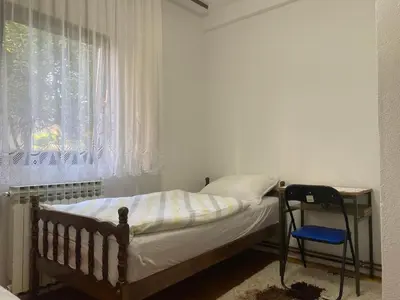 a small bedroom with a bed and a window at Lav Apartments in Bihać