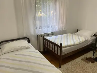 two twin beds in a room with a window at Lav Apartments in Bihać