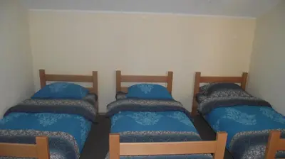 three beds in a room with blue pillows at Pansion Laktaši in Laktaši