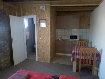 a kitchen and a dining room with a table and a kitchen at Pansion Laktaši in Laktaši