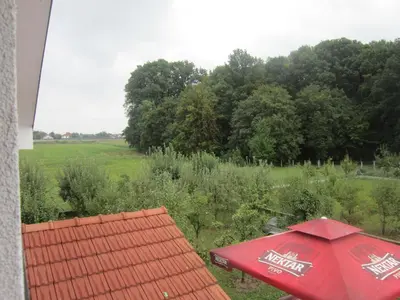 a red umbrella sitting next to a field at Pansion Laktaši in Laktaši