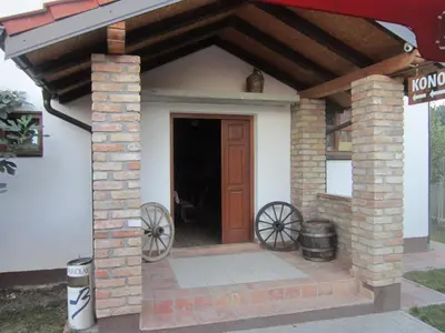 a small house with two wagon wheels and a door at Pansion Laktaši in Laktaši