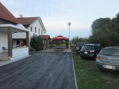 a driveway with cars parked in front of a house at Pansion Laktaši in Laktaši