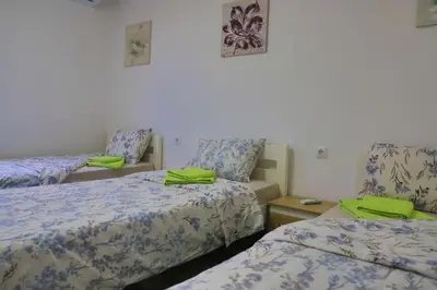 a room with two beds with green towels on them at Holiday Homes Pozitiva in Bihać